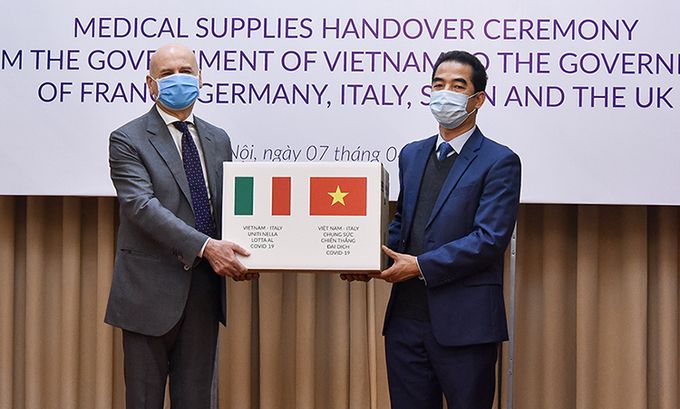 Thứ trưởng Tô Anh Dũng (phải) trao tượng trưng số khẩu trang cho Đại sứ Italy tại Việt Nam Atonio Alessandro ở trụ sở Bộ Ngoại giao hôm nay. Ảnh: Bộ Ngoại giao.